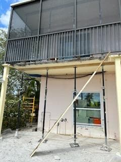 Building exterior showing scaffolding and temporary support structures during concrete structural restoration