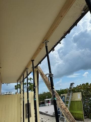 Temporary wood bracing and shoring supporting balcony underside during concrete structural restoration